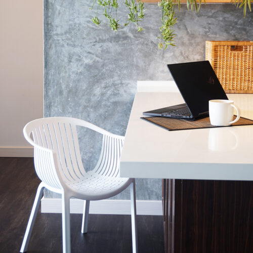 a white chair next to a laptop