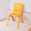 a yellow plastic chair leaning against a wall