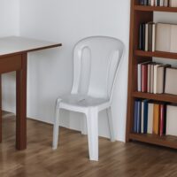 a white chair next to a book shelf