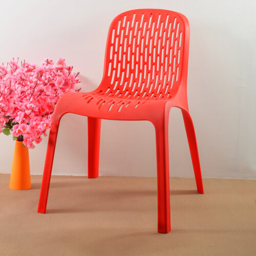 a red plastic chair next to a vase of flowers