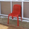 a red plastic chair on a patio