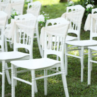 a group of white chairs with white bows